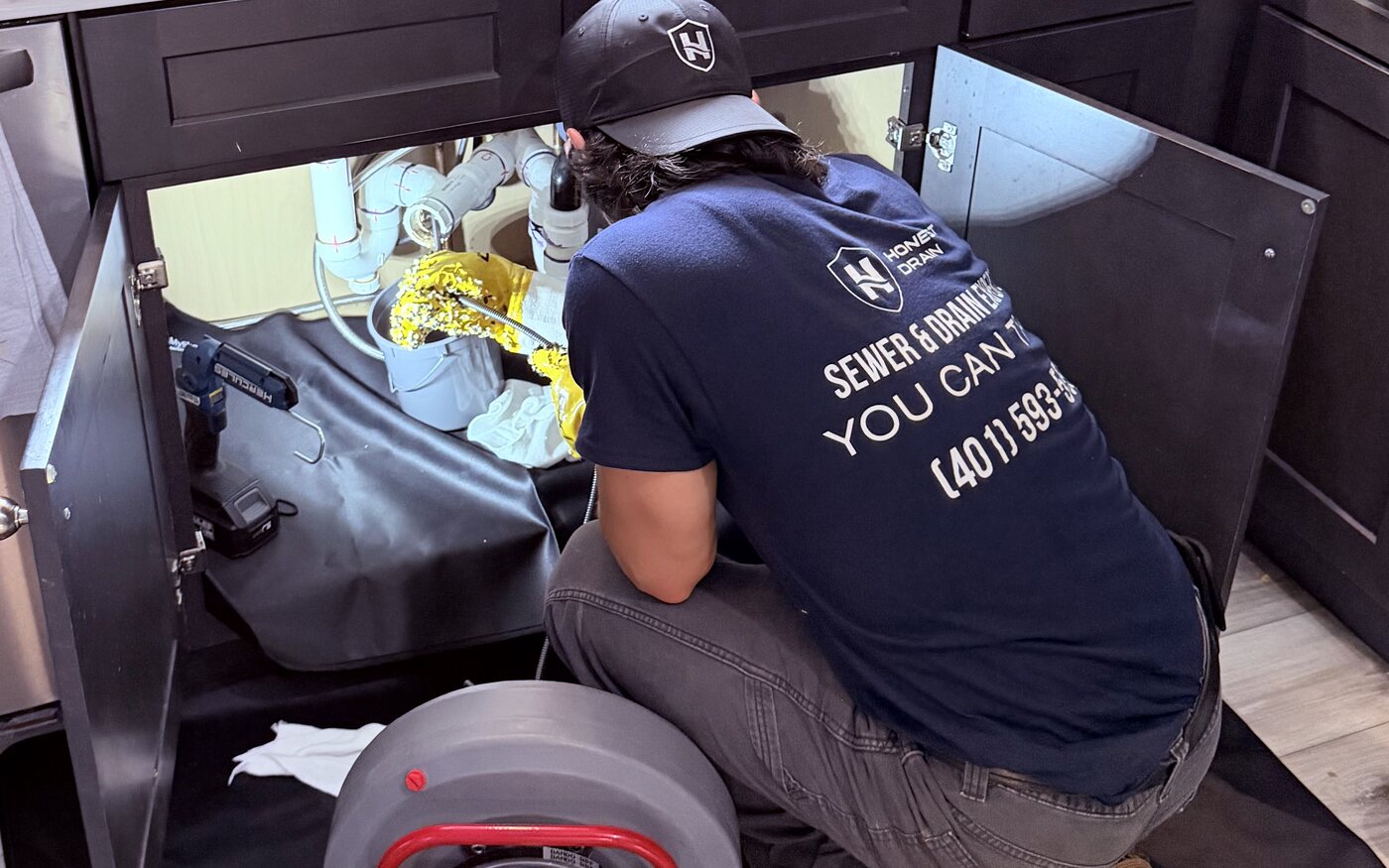 Honest Drain technician clearing a kitchen sink line